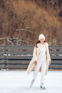 Full length portrait of woman standing in snow