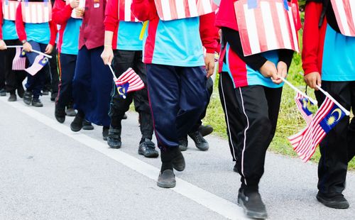 Low section of marching band holding malaysian flag