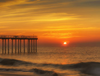 Scenic view of sea against orange sky