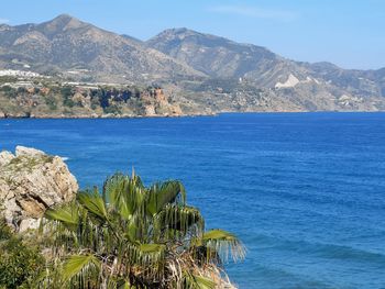 Scenic view of sea and mountains against sky