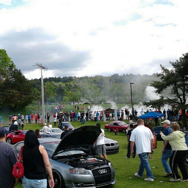 men, large group of people, tree, lifestyles, leisure activity, sky, person, cloud - sky, transportation, land vehicle, togetherness, car, rear view, mode of transport, street, crowd, mixed age range, green color, mountain