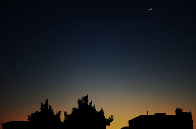 Low angle view of silhouette trees against clear sky