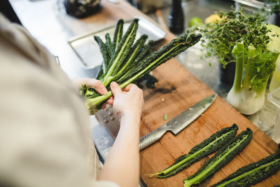 Midsection of female chef preparing vegetable at kitchen