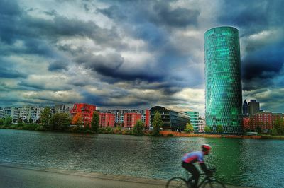 Man with umbrella in city against storm clouds