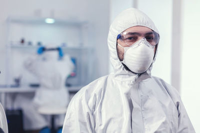 Portrait of woman wearing hat standing in laboratory
