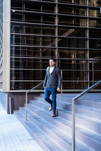 Young bearded man walking down the stairs of an office building person