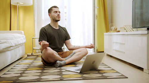 Young man using mobile phone at home