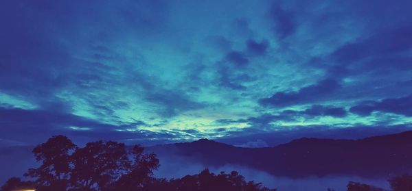 Low angle view of silhouette mountain against dramatic sky