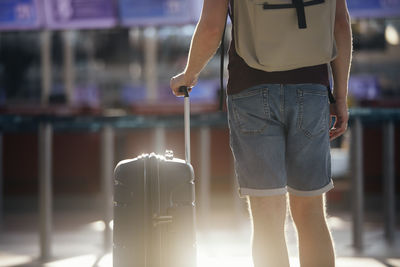 Traveling by airplane. selective focus on hand of man holding suitcase at airport.