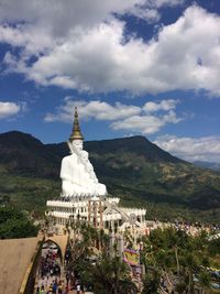 Buddha sculpture at temple against mountains