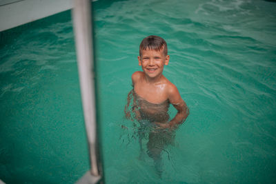 High angle view of shirtless boy in swimming pool