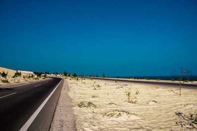 Road against clear blue sky