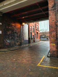 Empty road amidst buildings in city