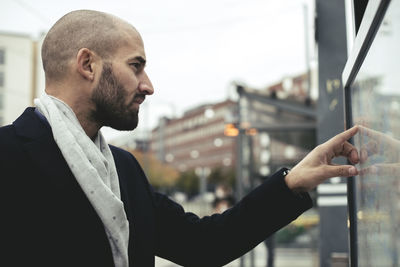 Mid adult businessman reading map in city