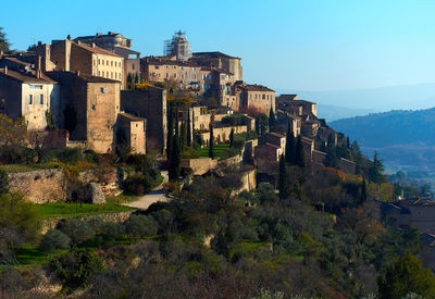 Houses on hill at gordes against sky
