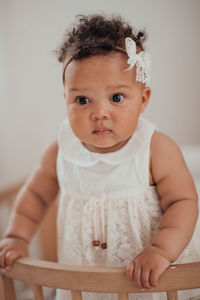 Portrait of cute baby girl sitting at home