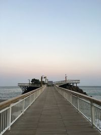 Pier on sea against clear sky