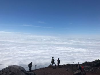 People on mountain against sky