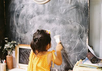 Rear view of girl standing at home