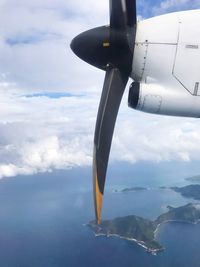 Close-up of airplane flying over sea against sky