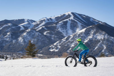 A woman riding her fat bike on a beautiful winter day in sun valley.