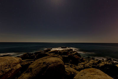 Scenic view of sea against clear sky at night