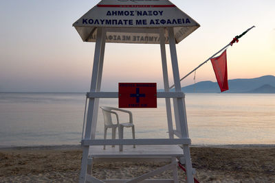 Information sign on beach against sky