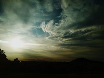 Silhouette of landscape against cloudy sky