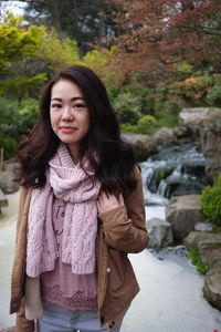 Portrait of young woman standing in front of scenery