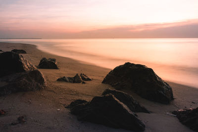 Long exposure sea rocks magnificent sunrise view at sunrise romantic in morning at sea. pink horizon