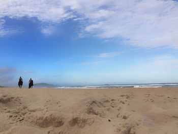 People on beach against sky