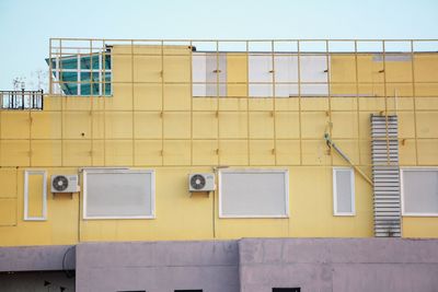 Low angle view of yellow building against clear sky