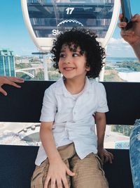 Portrait of smiling boy sitting in cable car