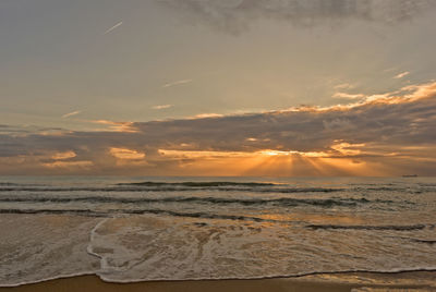 Scenic view of beach against sky during sunset