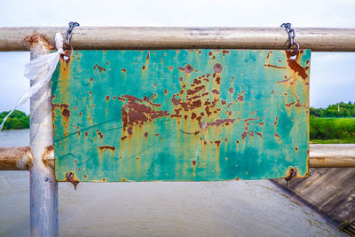 Close-up of rusty metal hanging on beach against sky