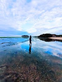 Man standing on beach against sky