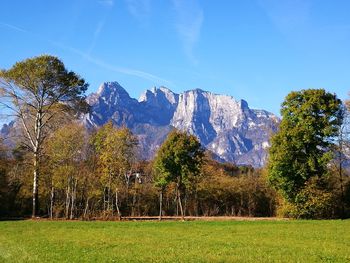 Scenic view of green landscape and mountains against sky