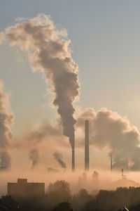 Smoke emitting from chimney against sky