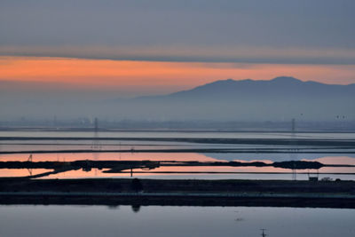 Scenic view of lake against orange sky