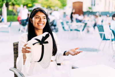 Smiling young woman sitting on chair