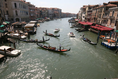 High angle view of boats on canal amidst buildings