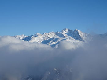 Scenic view of snowcapped mountains against clear blue sky