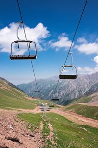 Overhead cable cars over mountains against sky