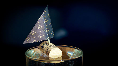 Close-up of boat in a glass on table against black background