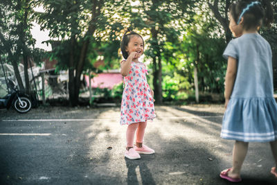 Rear view of girl standing against trees