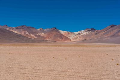 Scenic view of desert against clear blue sky