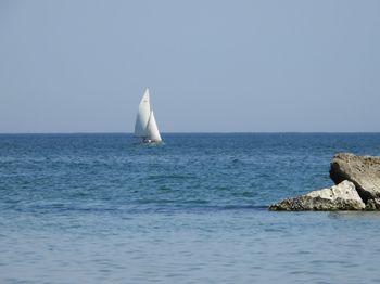 Sailboat in sea against clear sky