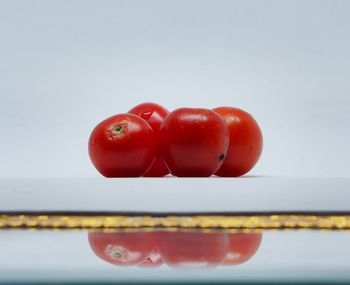 Close-up of red berries over white background