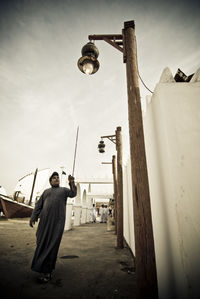 Man standing on street against sky