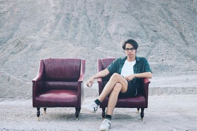 Portrait of young man sitting on chair